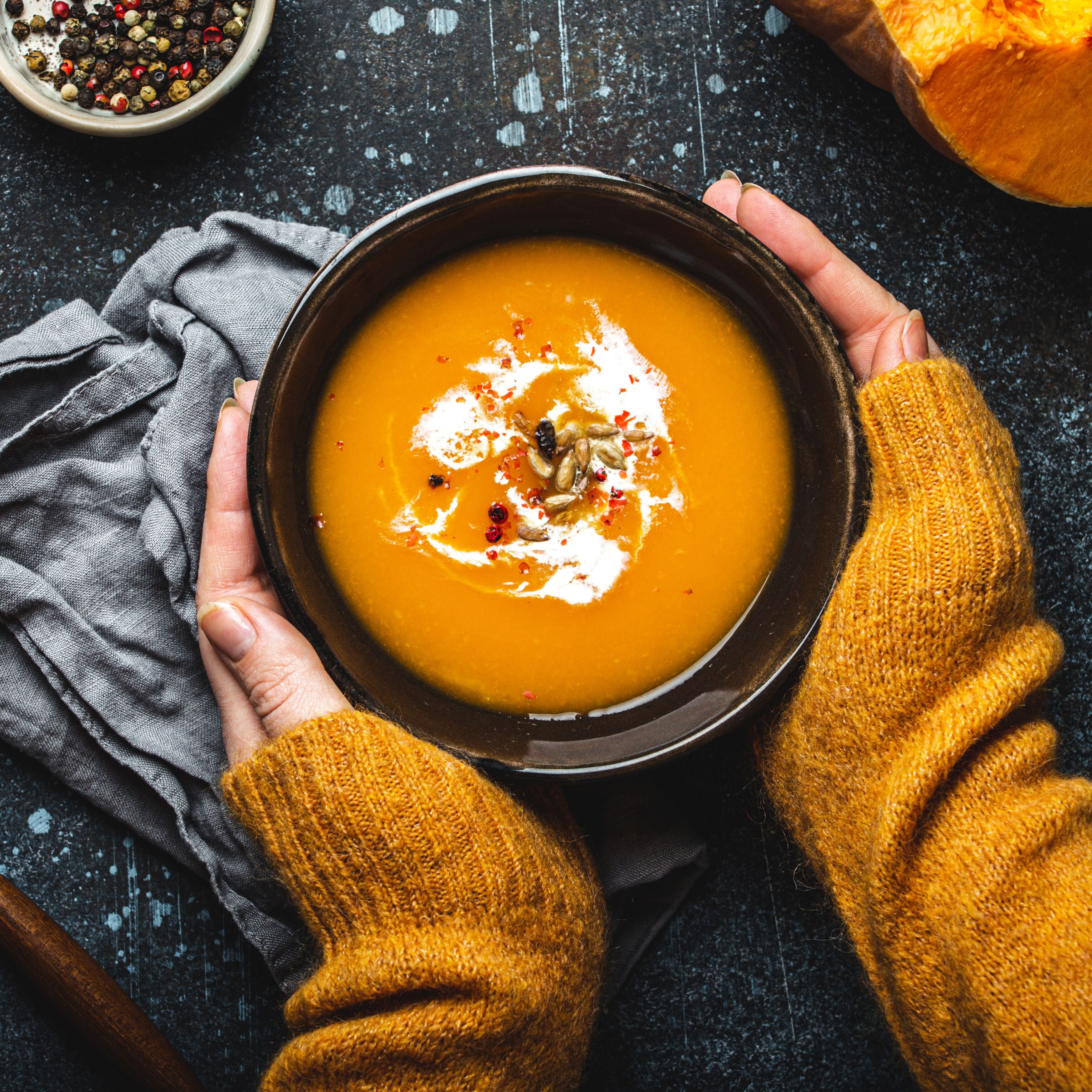 Female hands with bowl of pumpkin soup